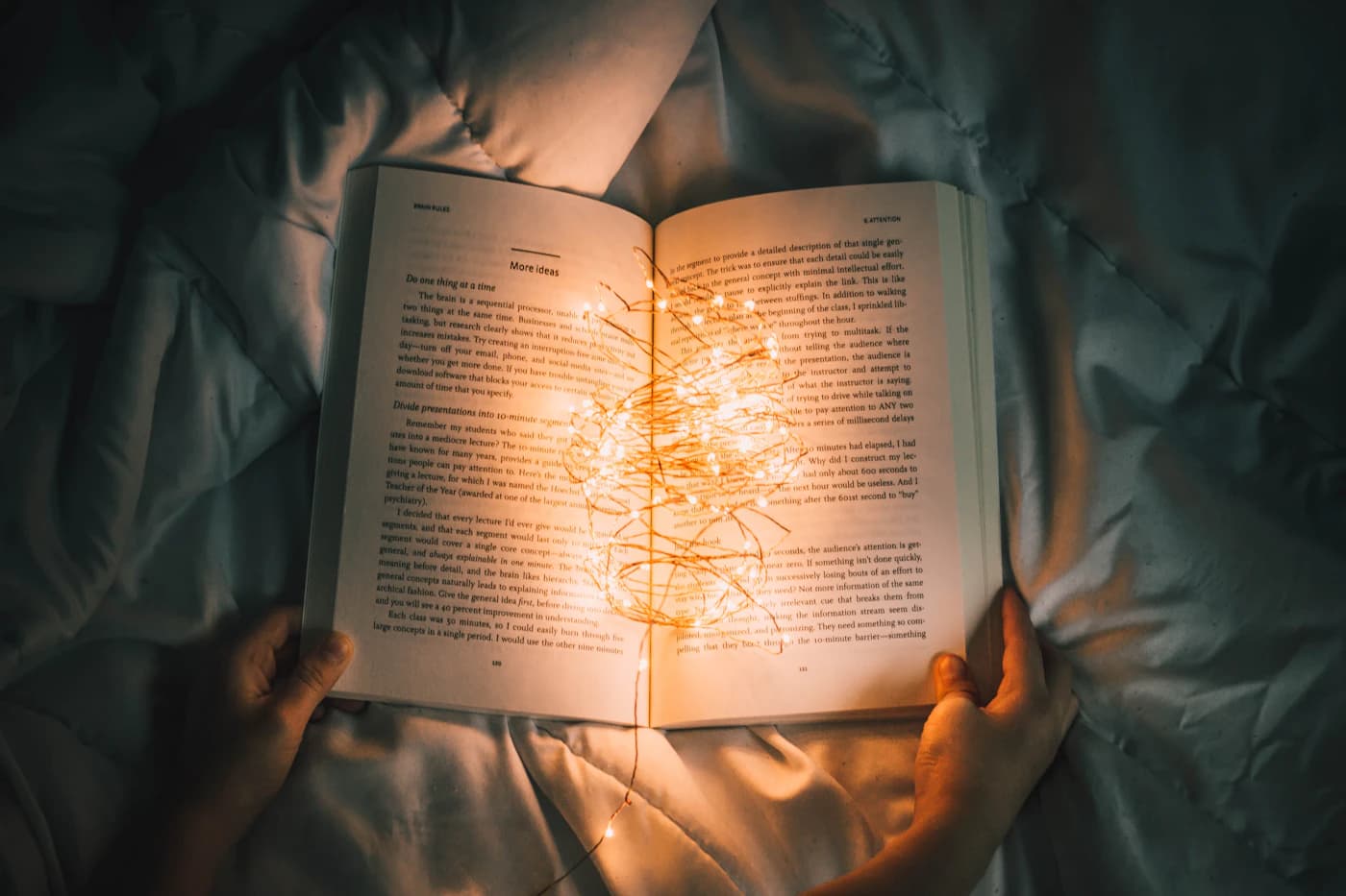 کتابی که نورهای ریز دورش را گرفتهاند، در تاریکی اتاق